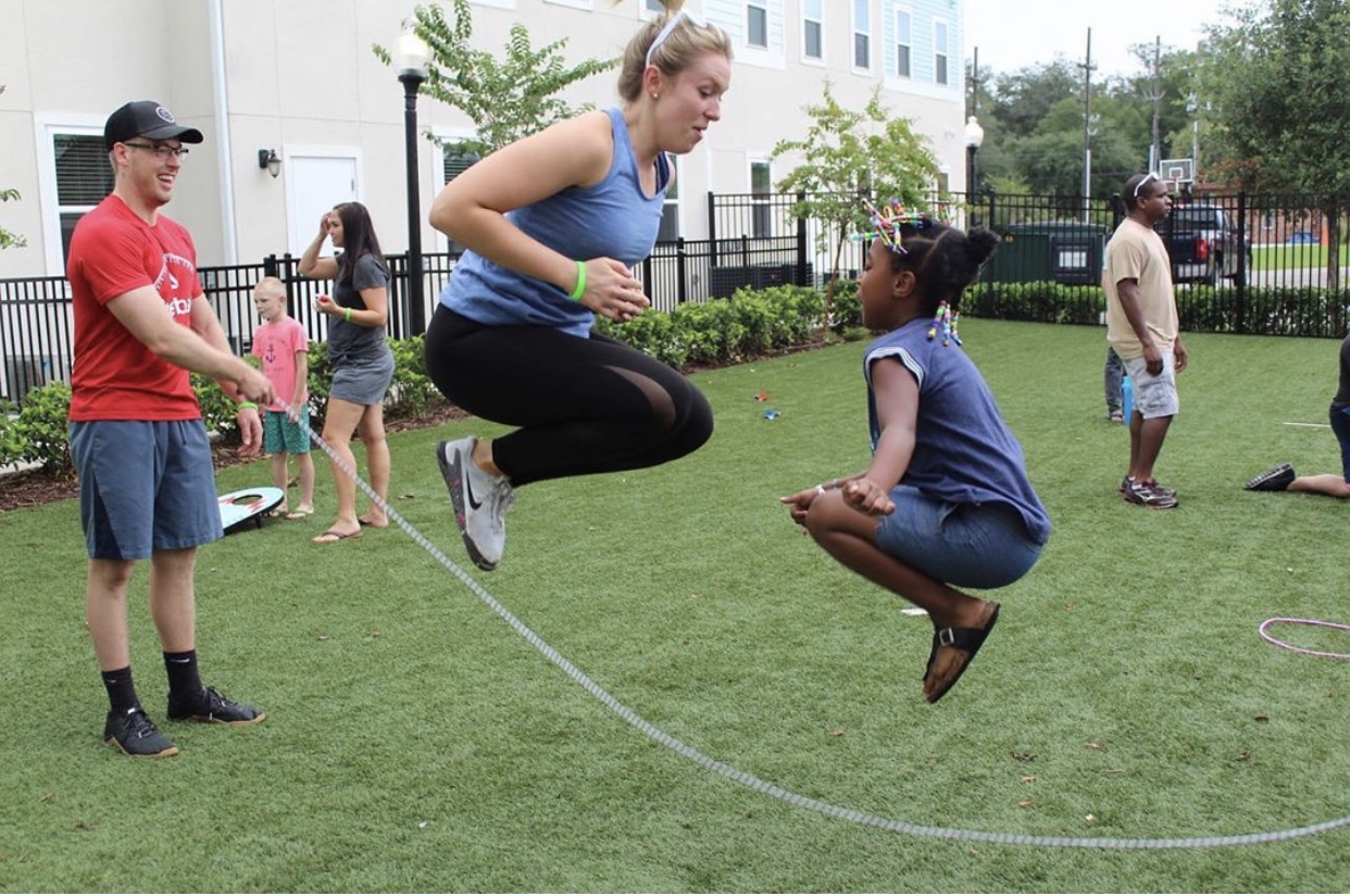 COE volunteer jump roping w child